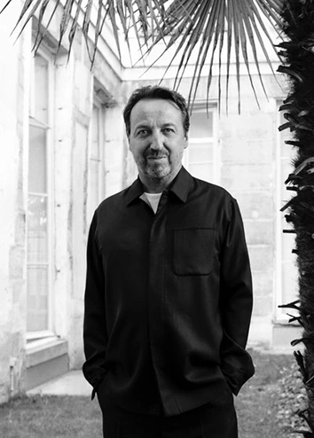 Portrait of Emmanuel Perrotin standing outdoors in a black-and-white photo