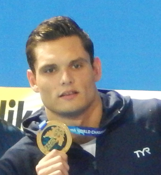 Florent Manaudou holding a medal at a swimming event