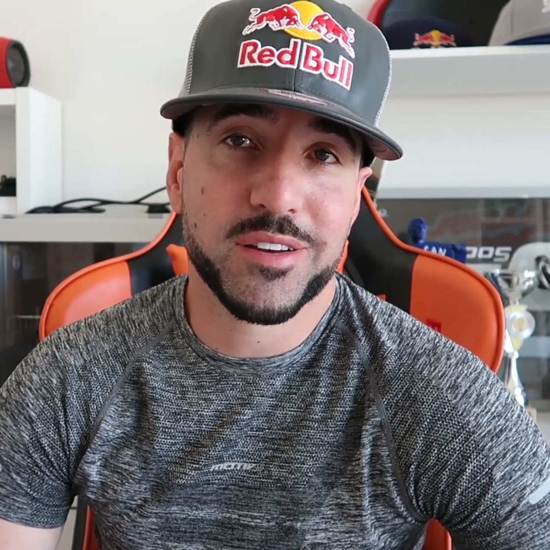 Séan Arnaud Garnier portrait photo wearing a Red Bull cap, seated indoors