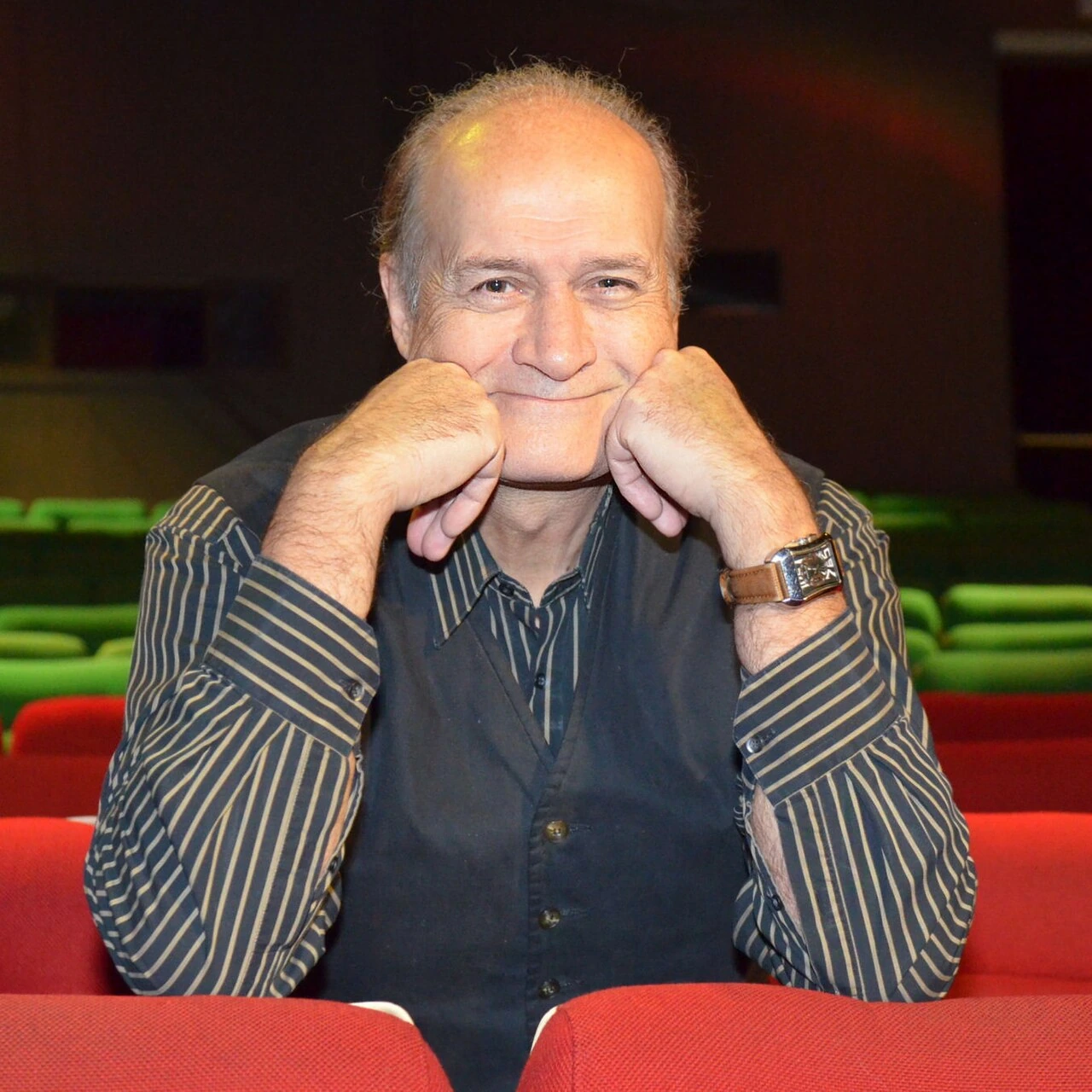 Jacques Vermeire seated indoors, smiling at the camera