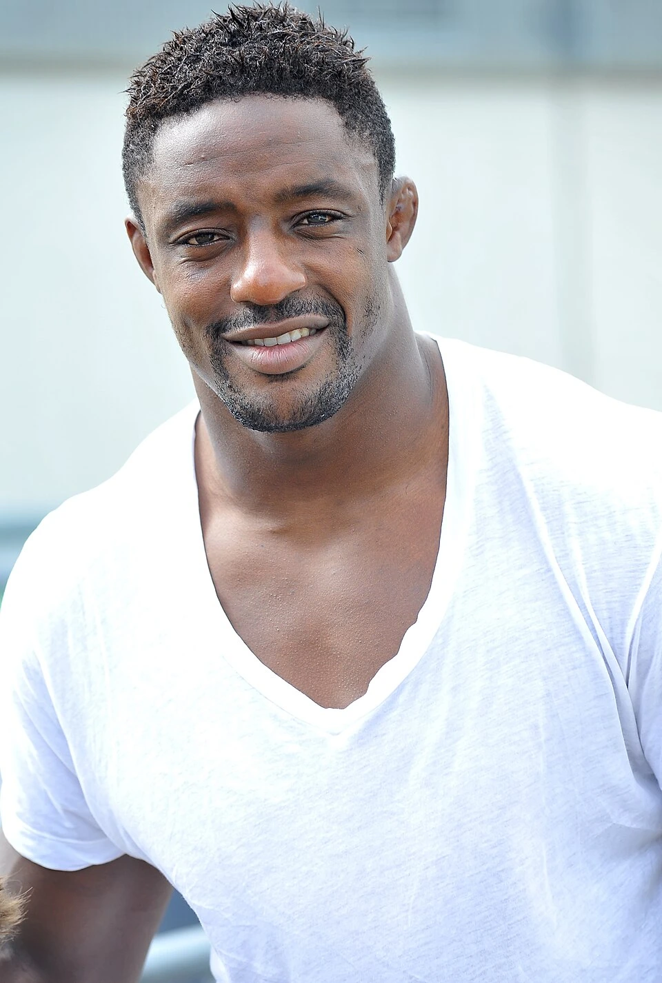 Portrait of Yannick Nyanga smiling in a white shirt.