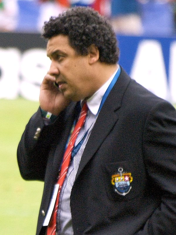 Serge Blanco in a suit on the sidelines at a rugby match